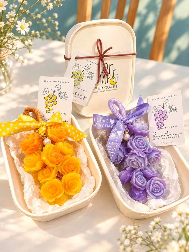 Hai chùm xà phòng hoa hồng vàng và tím trong hộp quà Moon Soap, kèm thẻ Grape Soap Series